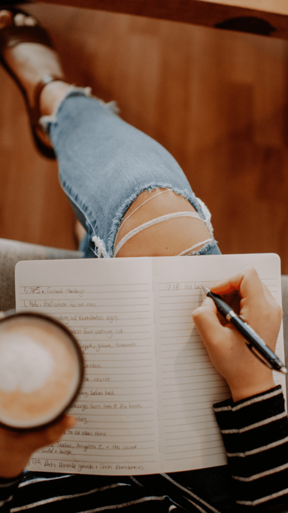 person writing on a journal