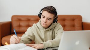 Teen student studying with laptop and notebook while practicing responsibility and follow-through.